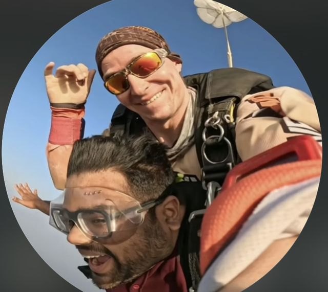 Rishab Saraf on a tandem skydive, with his instructor behind him